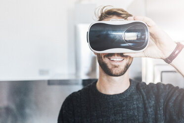 Lächelnder Mann mit Virtual-Reality-Brille - GIOF03185