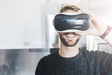 Smiling man wearing Virtual Reality Glasses - GIOF03185