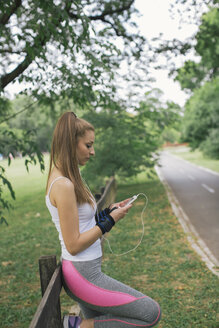 Sportliche Frau bei einer Pause im Park - MOMF00226
