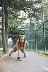 Young woman exercising on lane in park - MOMF00233