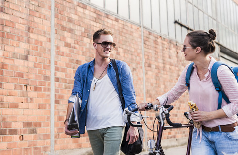 Young couple with bicycle walking and talking stock photo