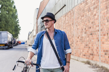 Junger Mann mit Fahrrad auf der Straße - UUF11521