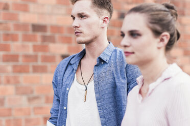Young couple in front of brick wall - UUF11524