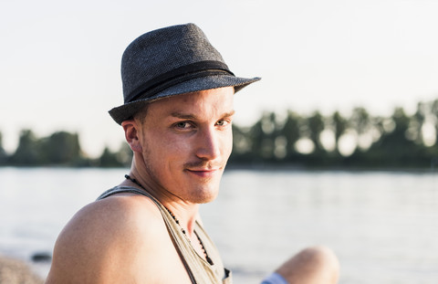 Portrait of young man wearing a hat at the riverbank stock photo