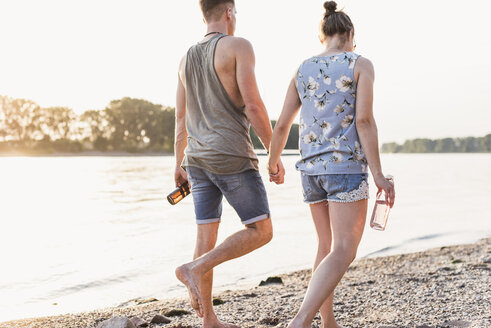 Young couple walking at the riverbank - UUF11543