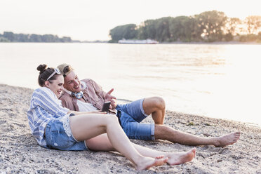 Young couple relaxing at the riverbank - UUF11551