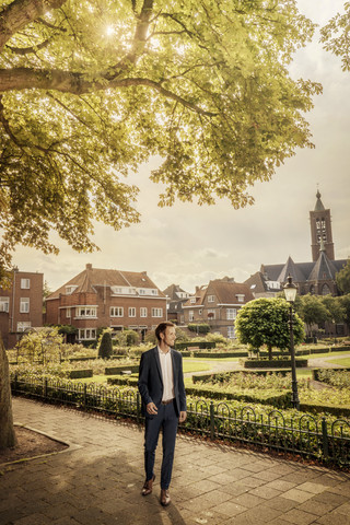 Niederlande, Venlo, Geschäftsmann auf dem Bürgersteig stehend, lizenzfreies Stockfoto