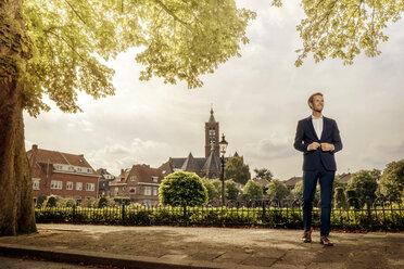 Niederlande, Venlo, Geschäftsmann auf dem Bürgersteig stehend - KNSF02410