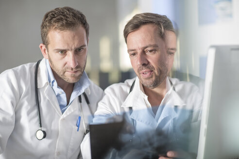 Zwei Ärzte besprechen ein Röntgenbild - ZEF14514