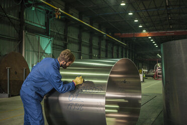 Worker labeling metal in factory - ZEF14518