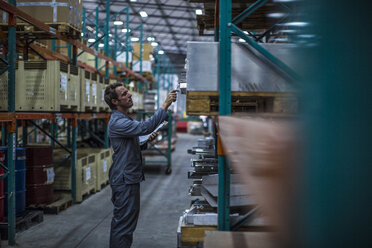 Worker in factory warehouse taking stock - ZEF14532