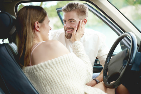 Affectionate young couple in car stock photo