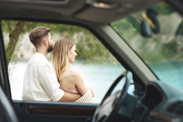 Junges Paar vor dem Auto mit Blick auf die Aussicht - ABIF00003