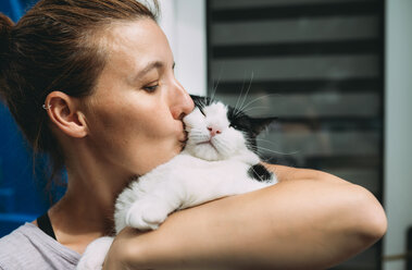Woman holding and kissing her cat - GEMF01772