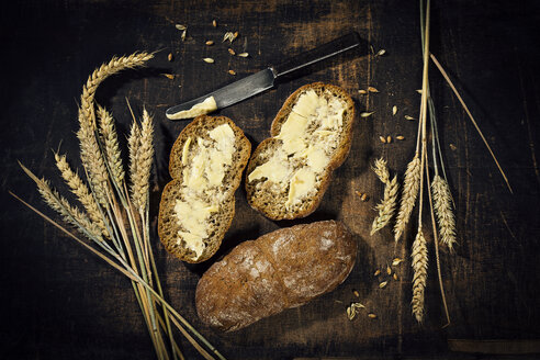 Butterbrot und Weizenähren auf dunklem Holz - MAEF12403