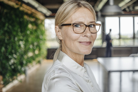 Porträt einer selbstbewussten Geschäftsfrau im Büro, lizenzfreies Stockfoto