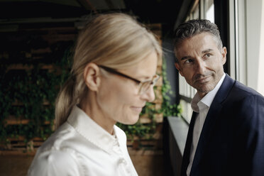 Portrait of confident businessman and businesswoman at the window - JOSF01401