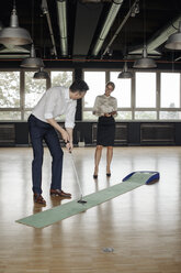 Businessman playing golf in office - JOSF01413