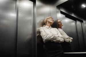 Erschöpfte Geschäftsfrau im Aufzug - JOSF01434