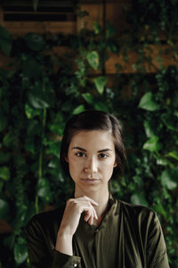 Porträt einer jungen Frau an einer Wand mit Kletterpflanzen - JOSF01455