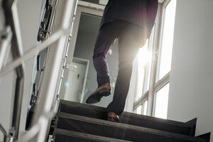 Beine eines Geschäftsmannes, der die Treppe hinaufgeht - JOSF01496