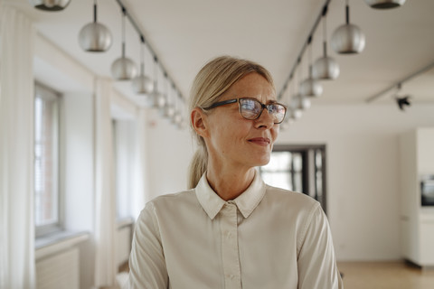 Porträt einer lächelnden Geschäftsfrau im Büro, lizenzfreies Stockfoto