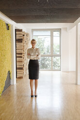 Confident businesswoman standing on office floor - JOSF01522