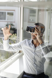 Geschäftsmann am Fenster mit VR-Brille - KNSF02462