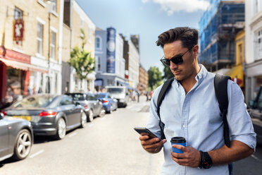 UK, London, Nottinghill, man looking at smartphone - MGOF03592