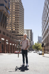 Mature man carrying his bicycle on his shoulders - WESTF23481