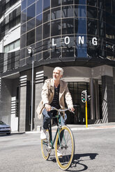 Mature man riding bicycle in the city - WESTF23498
