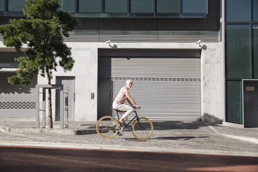Älterer Mann fährt Fahrrad in der Stadt - WESTF23574
