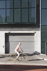 Mature man riding bicycle in the city - WESTF23575