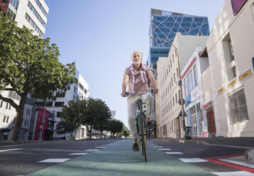 Älterer Mann fährt Fahrrad in der Stadt - WESTF23576