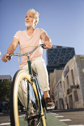 Mature man riding bicycle in the city - WESTF23578