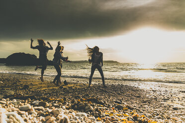 Excited friends on the beach at sunset - UUF11647