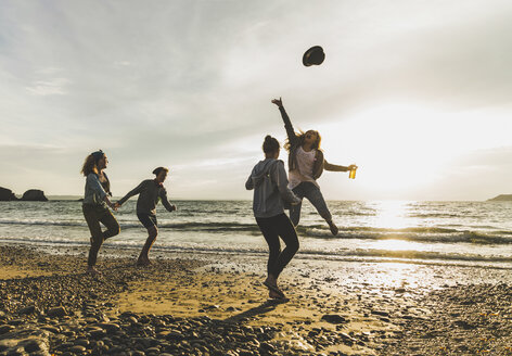 Aufgeregte Freunde am Strand bei Sonnenuntergang - UUF11648