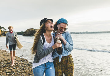 Happy friends with drinks on the beach - UUF11656