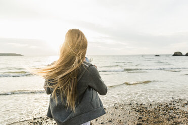 Young woman watching the sunset on the beach - UUF11657