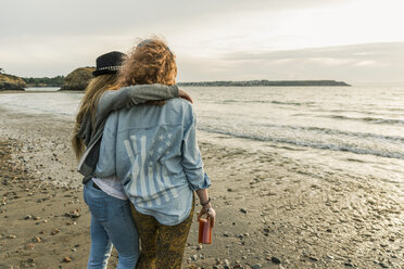 Beste Freunde beobachten den Sonnenuntergang am Strand - UUF11659