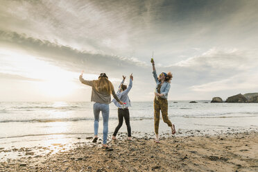 Happy friends making soap bubbles on the beach - UUF11666