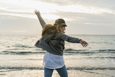 Happy young woman on the beach at sunset - UUF11671