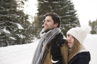 Glückliches junges Paar im schneebedeckten Winterwald - HAPF02034