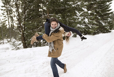 Happy young couple having fun in snow-covered winter landscape - HAPF02036