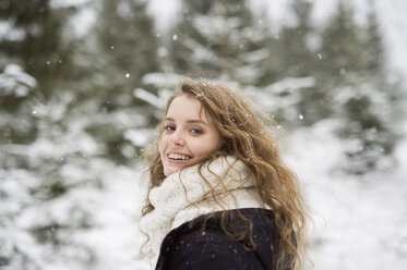 Portrait of smiling young woman in winter forest - HAPF02074
