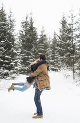 Glückliches junges Paar hat Spaß im verschneiten Winterwald - HAPF02075