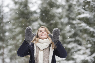 Portrait of happy young woman at snowfall in nature - HAPF02078