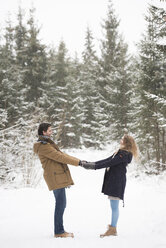 Glückliches junges Paar steht Hand in Hand in einer Winterlandschaft - HAPF02082