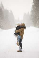 Happy young couple face to face in snow-covered winter landscape - HAPF02094