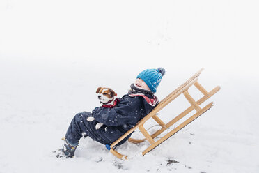 Kleiner Junge mit seinem Hund auf einem Schlitten im Schnee - MJF02164